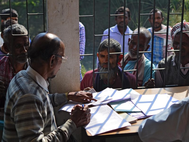 People wait to check their names on the first draft of the National Register of Citizens (NRC) at Goroimari of Kamrup district in the Indian state of Assam on January 1, 2018. Around 13 million people in northeastern India's Assam woke up to uncertainty on January 1 after the release of an official citizenship registry with names of only 19 million of the state's over 32 million residents. The national registry of citizens (NRC) has been in works for years, after strident, decades long demands by many local groups to identify and evict "illegal foreigners" settling in the state. / AFP PHOTO / Kulendu Kalita