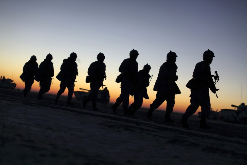 Soldiers of the People's Liberation Army (PLA) Marine Corps march during a military drill as the sun rises at a military base in Taonan, Jilin province. Photo: Reuters/China Daily