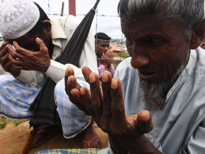 Rohingya refugees perform prayers as they attend a ceremony organized to remember the first anniversary of a military crackdown that prompted a massive exodus of people from Myanmar to Bangladesh, at the Kutupalong refugee camp in Ukhia on August 25, 2018. Photo: AFP / Dibyangshu Sarkar