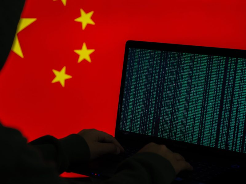 Conceptual image of a computer hacker juxtaposed against a Chinese flag.  Image: iStock/Getty Images