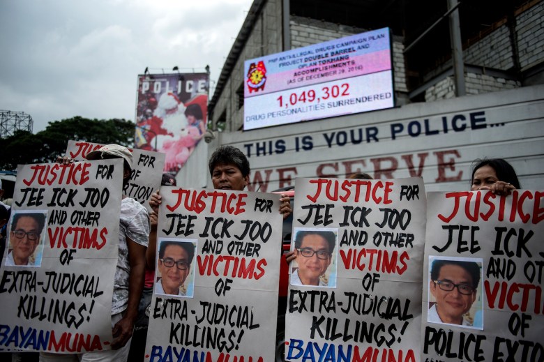 Activists hold a protest in front of Camp Crame, the headquarters of the Philippine National Police (PNP), carrying mock dead bodies, condemning the government's War on Drugs and holding placards showing the picture of the late South Korean businessman Jee Ick-Joo, who was murdered allegedly by suspected policemen in Manila on January 27, 2017.The South Korean businessman was allegedly kidnapped by Philippine policemen under the guise of a raid on illegal drugs and murdered at the national police headquarters in Manila, authorities said on January 18. / AFP PHOTO / NOEL CELIS