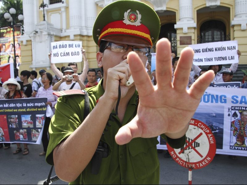 A policeman blocks photographers from taking pictures during an anti-China protest in front of the Opera House in Hanoi in a file photo. Photo: Reuters/Nguyen Lan Thang